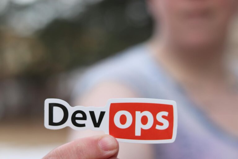 DevOps 介紹 A close-up image featuring a DevOps sticker held by a person outdoors.