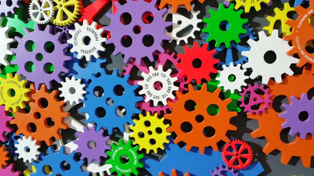 自動化工具介紹 A colorful arrangement of gears symbolizing creativity, innovation, and machinery in vibrant colors.